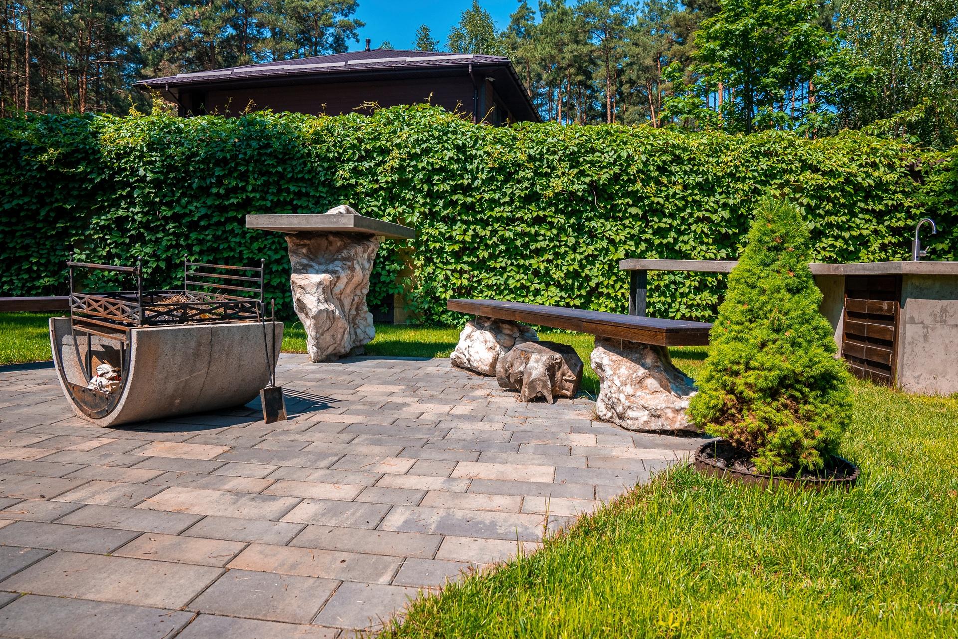 Gartenbereich mit rustikalen Möbeln und Grillstelle | Terrassenüberdachung