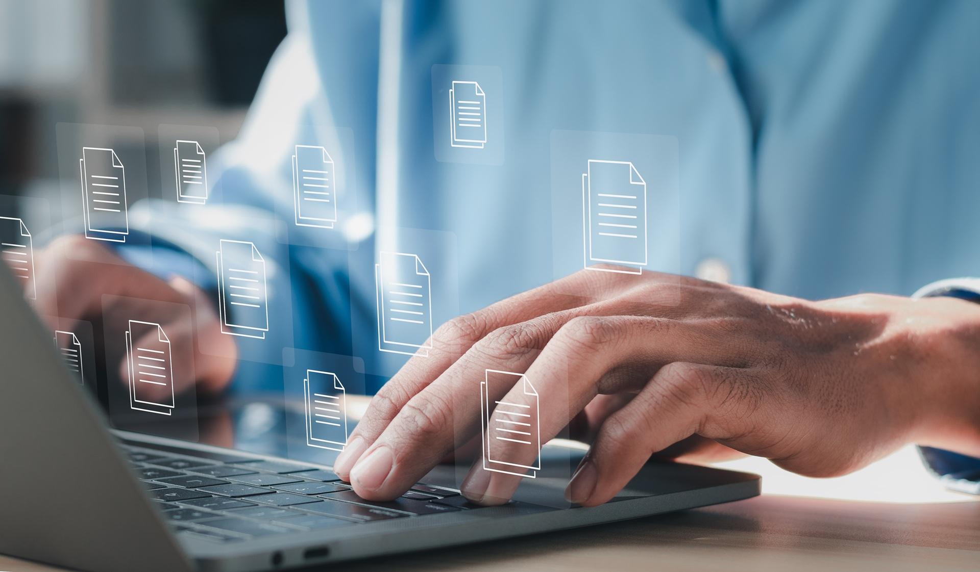 Person tippt auf Laptop mit digitalen Dokumenten | Auto online abmelden